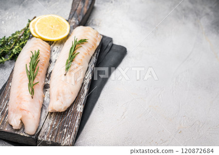 Raw cod Loin, white fish fillets without skin on wooden board. white background. top view Raw cod Loin, white fish fillets without skin on wooden board. white background. top view 120872684
