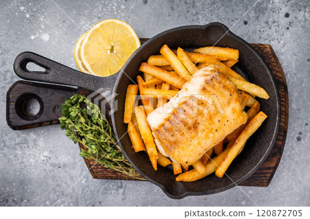 Fish and chips with roast white fish fillet and French fry in skillet. grey background. top view 120872705
