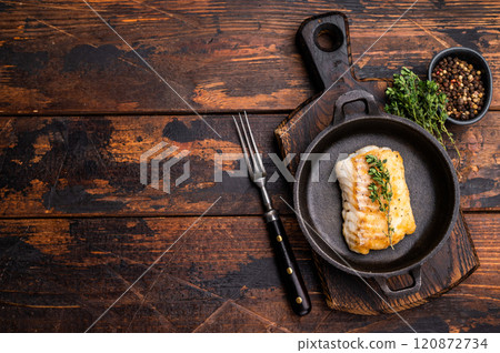 Roasted cod fish loin fiilet in skillet. Wooden background. top view Roasted cod fish loin fiilet in skillet. Wooden background. top view 120872734