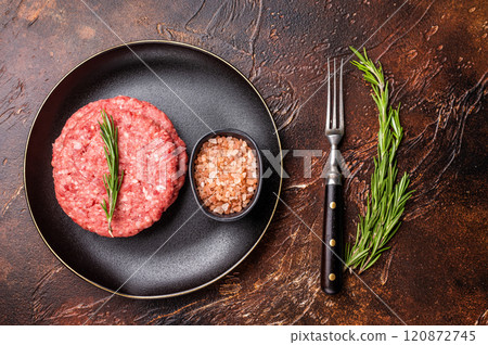 Raw veal and beef minced meat cutlets for burgers with herbs on plate. brown background. top view 120872745