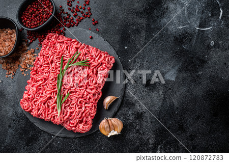 Uncooked beef veal Mince Meat, raw ground meat. Black background. Top view. Space for text Uncooked beef veal Mince Meat, raw ground meat. Black background. Top view. Space for text 120872783