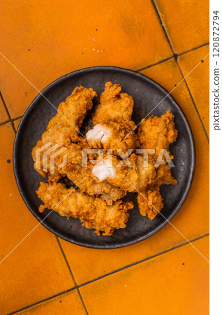 Chicken tenders, deep fried strips from breast fillet. orange background. top view Chicken tenders, deep fried strips from breast fillet. orange background. top view 120872794