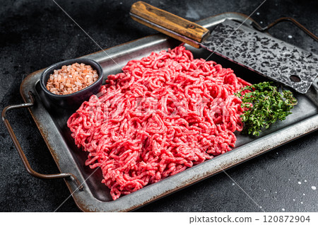Unccoked Mince Ground meat, raw mincemeat beef and pork in a kitchen tray. Black background. Top view Unccoked Mince Ground meat, raw mincemeat beef and pork in a kitchen tray. Black background. Top view 120872904