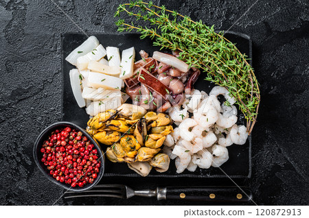Seafood assorted platter, mix of mussels, clams, squid, octopus, shrimps and prawn. Black background. Top view 120872913