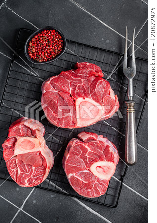 Fresh Osso buco Veal shank ready for cooking, raw cross cut veal shank. Black background. Top view 120872975