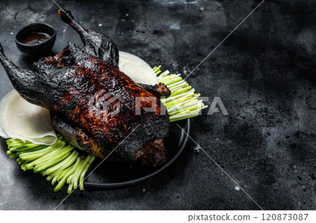 Traditional whole roasted Christmas Peking duck with herbs and sauce. Black background. Top view. Copy space 120873087