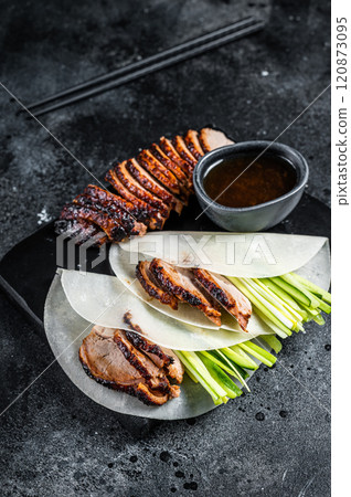 Traditional served Peking Duck with cucumber, green onion, in wheaten chinese pancakes. Black background. Top view 120873095