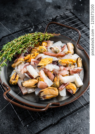 Raw Seafood mix, sea cocktail of fresh mussels, clams, squid, octopus, shrimps and prawn. Black background. Top view Raw Seafood mix, sea cocktail of fresh mussels, clams, squid, octopus, shrimps and prawn. Black background. Top view 120873100