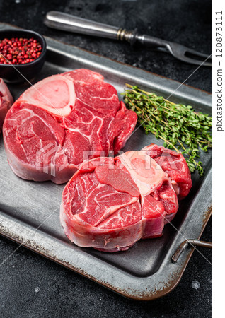 Fresh Raw Osso buco Veal steak, cross cut veal shank Ossobuco. Black background. Top view 120873111