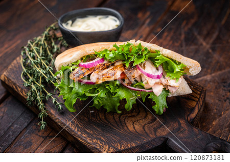 Doner kebab with grilled chicken meat, salad, tomato, onion in pita bread on wooden board. wooden background. top view 120873181