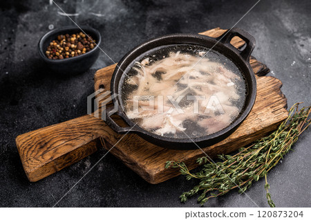 Chicken broth with meat, chicken soup in a skillet. black background. top view 120873204