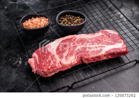 Ready for cooking Chuck eye roll steak, fresh raw beef meat on a rack. black background. top view Ready for cooking Chuck eye roll steak, fresh raw beef meat on a rack. black background. top view 120873262