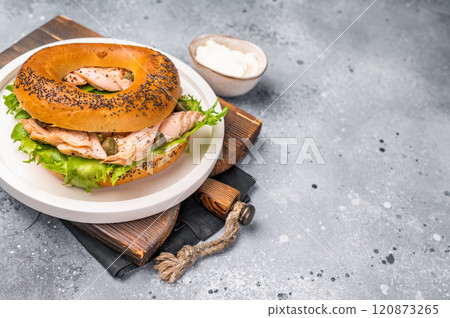 Branch with Bagel sandwich , lox, smoked salmon, lettuce and cream cheese on a plate. gray background. top view Branch with Bagel sandwich , lox, smoked salmon, lettuce and cream cheese on a plate. gray background. top view 120873265