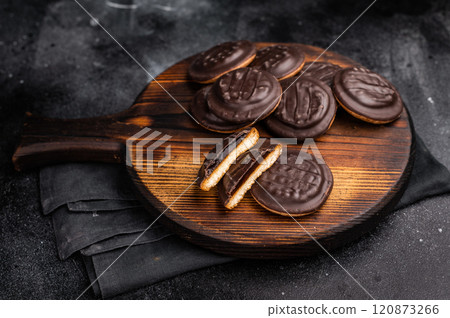 Jaffa Cookies covered with chocolate and filled with jam on wooden board. black background. top view 120873266