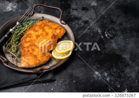 German Wiener schnitzel steak, breaded pork fillet meat. black background. top view German Wiener schnitzel steak, breaded pork fillet meat. black background. top view 120873267