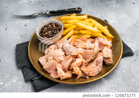 Dinner with Pulled salmon roast fillets and french fry on a plate. gray background. Top view Dinner with Pulled salmon roast fillets and french fry on a plate. gray background. Top view 120873275