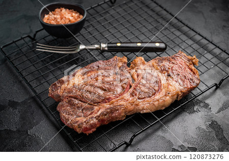 BBQ grilled Chuck eye roll steak, prime beef meat on a steel rack. black background. top view 120873276