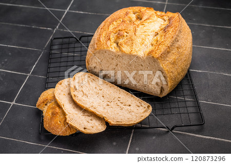 Handcrafted sliced tartin bread on steel rack. Black background. Top view Handcrafted sliced tartin bread on steel rack. Black background. Top view 120873296