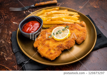 Wiener pork schnitzel steak, breaded meat with french fry on a plate. brown background. top view Wiener pork schnitzel steak, breaded meat with french fry on a plate. brown background. top view 120873297