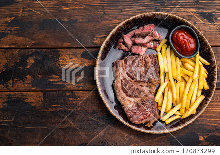 Dinner with grilled Chuck eye roll steak and french fry on a plate. wooden background. top view Dinner with grilled Chuck eye roll steak and french fry on a plate. wooden background. top view 120873299