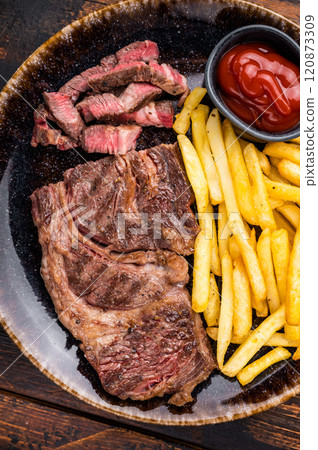 Dinner with grilled Chuck eye roll steak and french fry on a plate. wooden background. top view 120873309