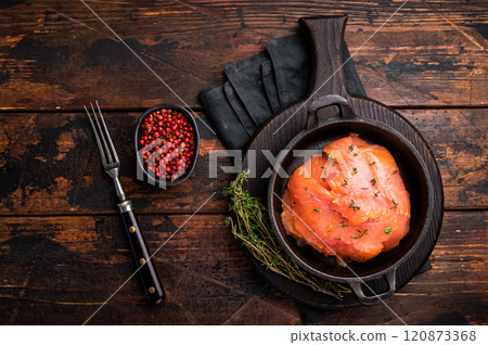 Salmon fillet slices with herbs in a skillet. wooden background. top view Salmon fillet slices with herbs in a skillet. wooden background. top view 120873368