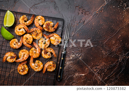 Grilled Shrimps Prawns with garlic on a rack. Brown background. Top view Grilled Shrimps Prawns with garlic on a rack. Brown background. Top view 120873382