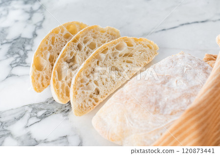 Italian baked and sliced ciabatta bread on a marble table. marble background. top view 120873441