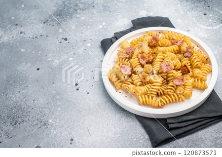 Carbonara pasta topped with crispy bacon bits and parmesan cheese in a plate. Gray background. Top view Carbonara pasta topped with crispy bacon bits and parmesan cheese in a plate. Gray background. Top view 120873571
