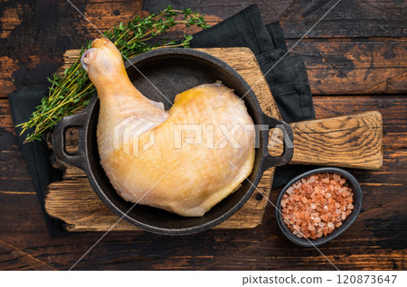 Raw farm chicken leg in a skillet ready for cooking, poultry fresh meat on wooden background, top view. Raw farm chicken leg in a skillet ready for cooking, poultry fresh meat on wooden background, top view. 120873647
