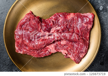 Alternative choice steak - Skirt or Machete, raw beef meat. Black background. Top view Alternative choice steak - Skirt or Machete, raw beef meat. Black background. Top view 120873719