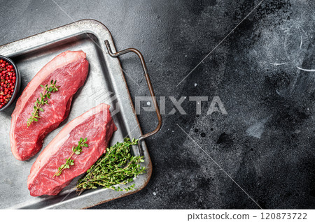 Top sirloin steak, raw beef meat steak with thyme and pepper on steel tray. Black background. Top view. Copy space Top sirloin steak, raw beef meat steak with thyme and pepper on steel tray. Black background. Top view. Copy space 120873722