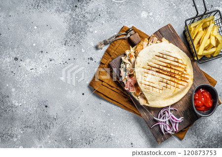 Doner kebab, Shawarma in grilled pita bread with vegetables and meat. Gray background. Top view. Copy space Doner kebab, Shawarma in grilled pita bread with vegetables and meat. Gray background. Top view. Copy space 120873753