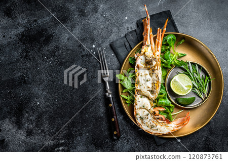 Grilled Spiny lobster with salad on a plate. Black background. Top view. Copy space Grilled Spiny lobster with salad on a plate. Black background. Top view. Copy space 120873761