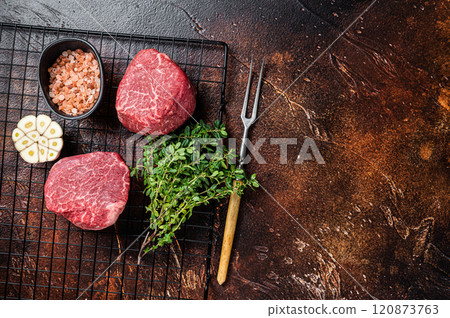 Raw Fillet Mignon Beef steaks, Dry aged tenderloin meat. Dark background. Top view. Space for text 120873763