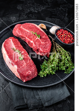 Dry aged Raw top blade flat Iron beef meat steaks. Black background. Top View Dry aged Raw top blade flat Iron beef meat steaks. Black background. Top View 120873863