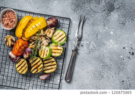 Seasonal summer Grilled vegetables on a grill, bell pepper, zucchini, eggplant, onion and tomato. Gray background. Top view. Copy space Seasonal summer Grilled vegetables on a grill, bell pepper, zucchini, eggplant, onion and tomato. Gray background. Top view. Copy space 120873865