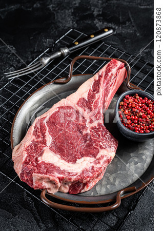 Dry aged Raw cowboy or rib eye steak. Black background. Top view 120873868