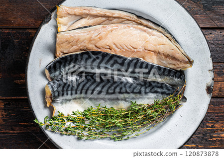 Salty sliced mackerel fillet fish in a plate with herbs. Wooden background. Top view Salty sliced mackerel fillet fish in a plate with herbs. Wooden background. Top view 120873878