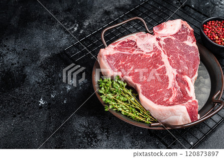Fresh raw T-bone marbled beef meat Steak on a steel tray. Black background. Top view. Copy space 120873897