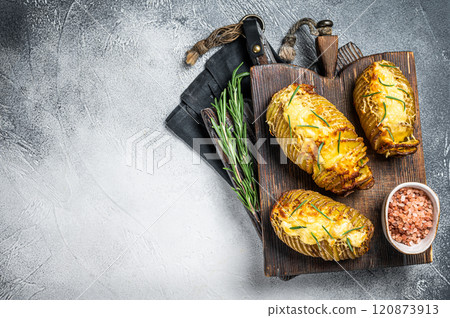 Roasted hasselback potatoes with cheese, garlic, thyme and rosemary. White background. Top view. Copy space 120873913