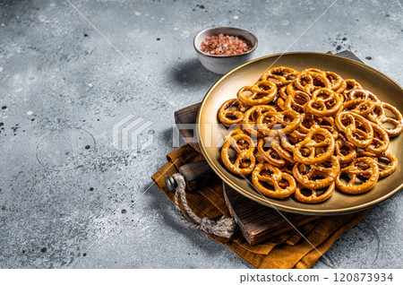 Mini pretzels crackers with salt. Gray background. Top view. Copy space Mini pretzels crackers with salt. Gray background. Top view. Copy space 120873934