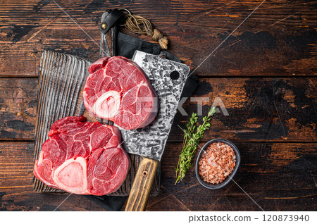 Raw Osso buco Veal shank ready for cooking, raw cross cut calf shank on a butcher board. Wooden background. Top view 120873940