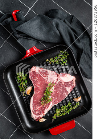 Raw T-bone or porterhouse beef meat Steak with thyme in a grill skillet ready for cooking. Black background. Top view Raw T-bone or porterhouse beef meat Steak with thyme in a grill skillet ready for cooking. Black background. Top view 120873956
