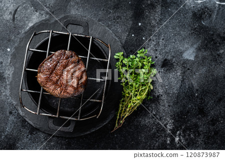 Fillet Mignon grilled beef Steak on a grill. Black background. Top view. Copy space 120873987