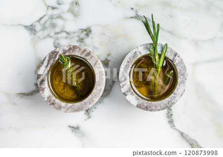 Flavoring: extra virgin olive oil with thyme and rosemary. Top view. White background 120873998