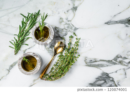 Flavoring: extra virgin olive oil with thyme and rosemary. Top view. White background. Copy space Flavoring: extra virgin olive oil with thyme and rosemary. Top view. White background. Copy space 120874001