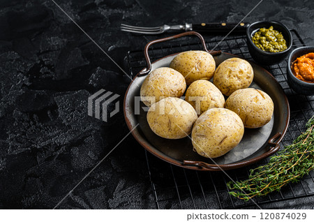 Canarian potatoes papas arrugadas with mojo, hot sauce. Black background. Top view. Copy space Canarian potatoes papas arrugadas with mojo, hot sauce. Black background. Top view. Copy space 120874029
