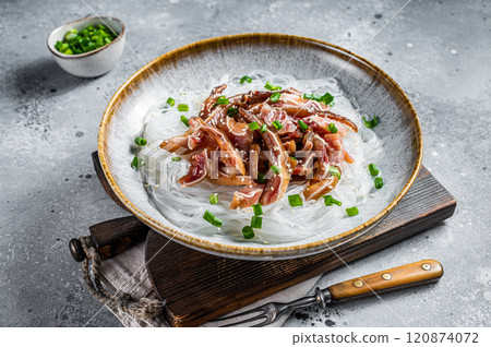 Salad with pork pig ears, glass noodles, sesame seeds and green onions. Fried pork ears in korean style. Gray background. Top view 120874072