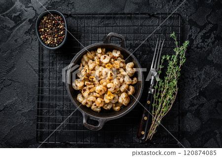 Roasted Shrimps with garlic, olive oil and spices in a skillet. Black background. top view 120874085